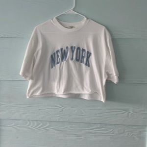 it white with blue lettering that says new york across the front
